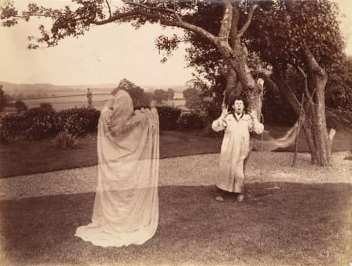 A man in a garden being frightened by a ghost. Old Victorian photograph.