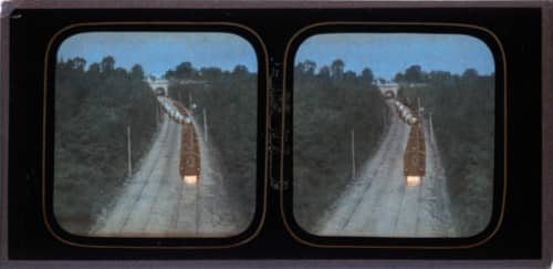 A stereo view of a ghost train travelling down some tracks. Old projector slide.